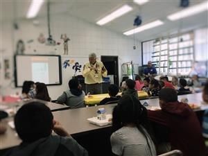 Search and Rescue gentleman showing students a special phone they use