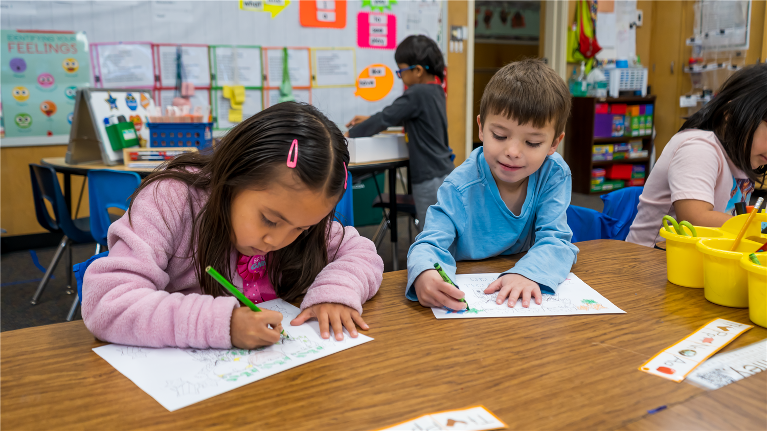 Students writing on a work sheet. Students writing on a work sheet.